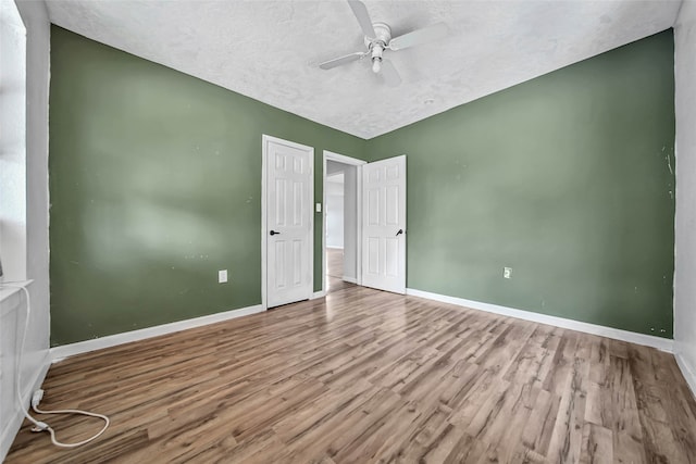 unfurnished bedroom with hardwood / wood-style floors, a textured ceiling, and ceiling fan