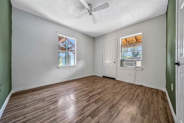 spare room with a textured ceiling, wood-type flooring, and cooling unit