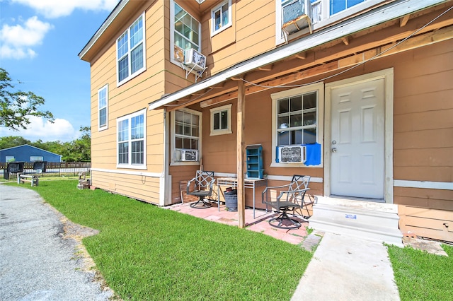 doorway to property with cooling unit and a yard