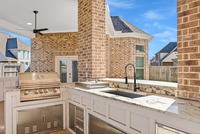 view of patio featuring exterior kitchen, area for grilling, sink, and ceiling fan