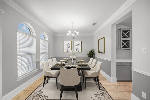 tiled dining area with ornamental molding and an inviting chandelier