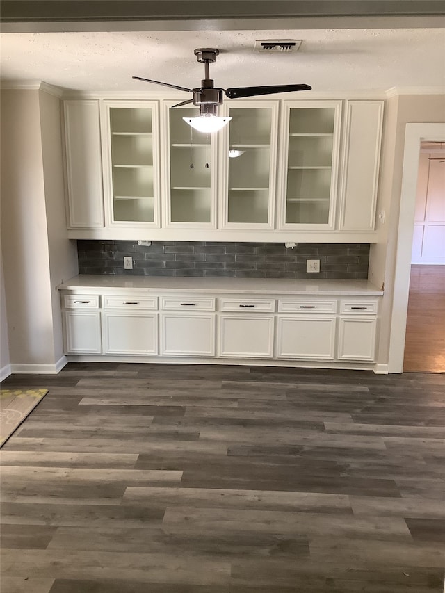 bar featuring white cabinets, dark wood-type flooring, and backsplash