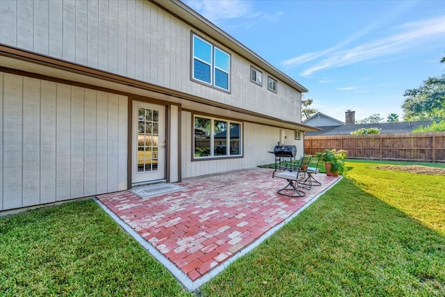 rear view of house featuring a patio area and a lawn