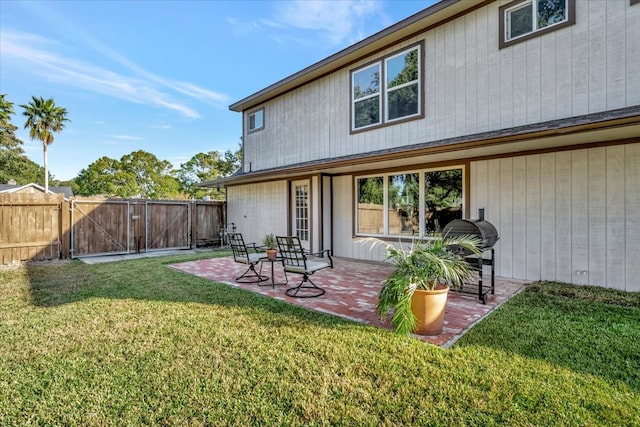 rear view of property featuring a patio area and a yard