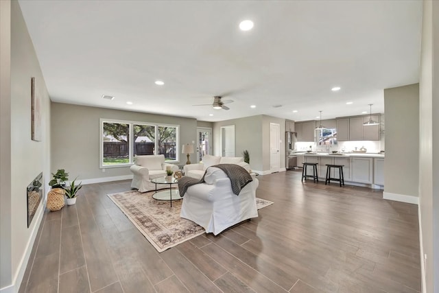 living room featuring ceiling fan and dark hardwood / wood-style flooring