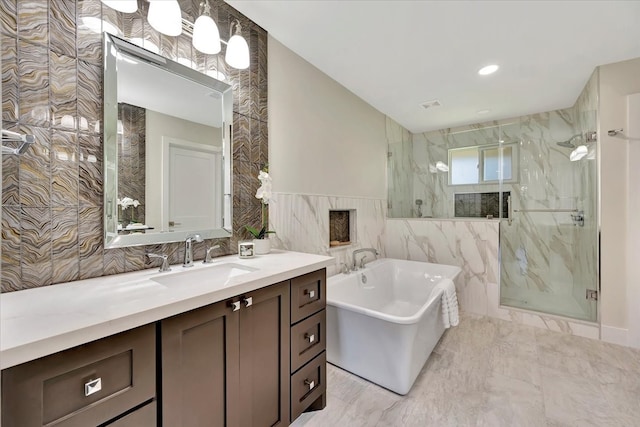 bathroom featuring vanity, tile walls, and separate shower and tub