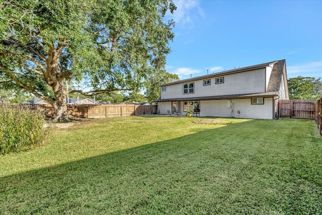 rear view of property featuring a lawn