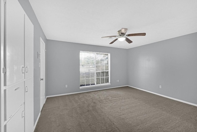 unfurnished bedroom with ceiling fan, carpet flooring, and baseboards