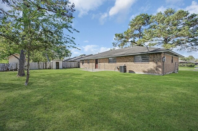 exterior space with a yard, a storage shed, and central AC