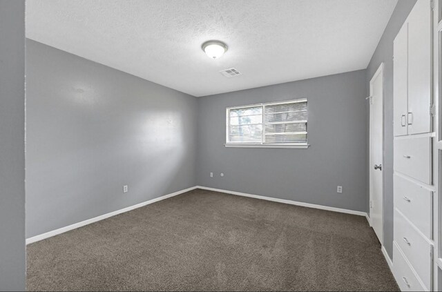 carpeted spare room featuring a textured ceiling