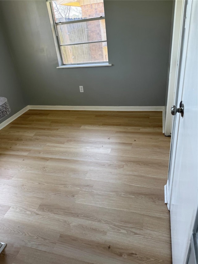 unfurnished room with light wood-style floors and baseboards