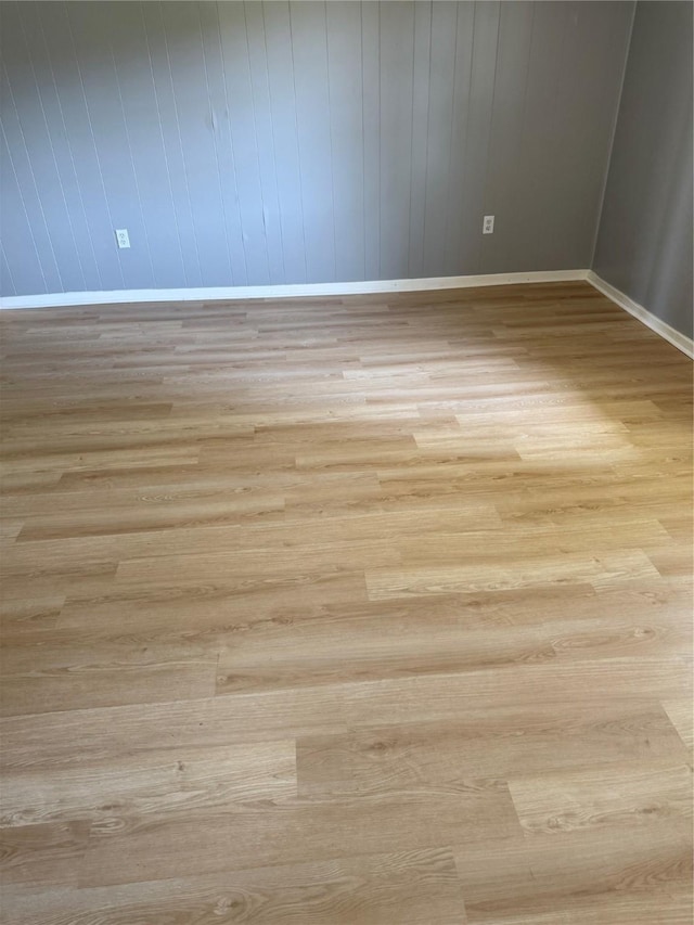 spare room with wood finished floors and baseboards