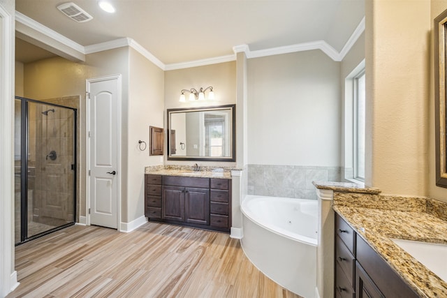 bathroom with vanity, crown molding, wood-type flooring, and separate shower and tub