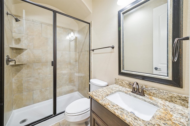 bathroom with a shower with door, vanity, and toilet