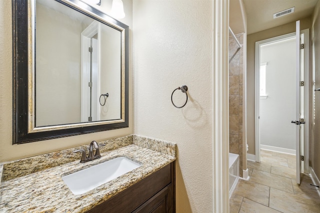 bathroom with vanity and tiled shower / bath combo