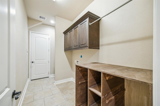 washroom with cabinets, light tile patterned flooring, and washer hookup