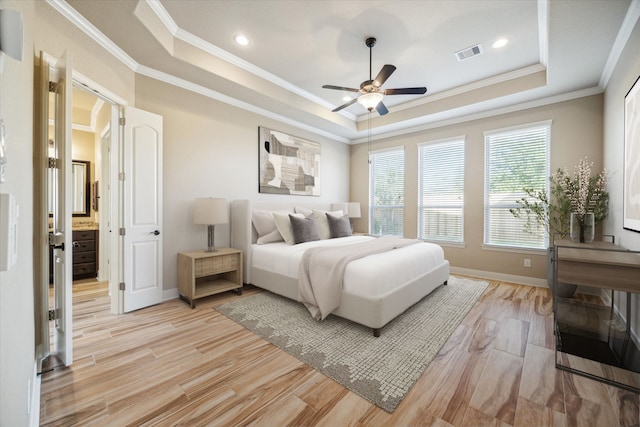 bedroom featuring light hardwood / wood-style floors, a raised ceiling, ornamental molding, and ceiling fan