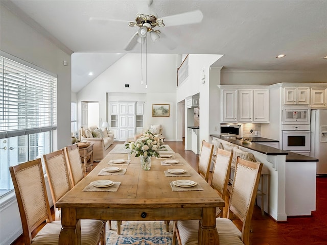 dining area with dark hardwood / wood-style flooring, ornamental molding, high vaulted ceiling, and ceiling fan