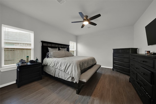 bedroom with dark wood-type flooring, ceiling fan, and multiple windows