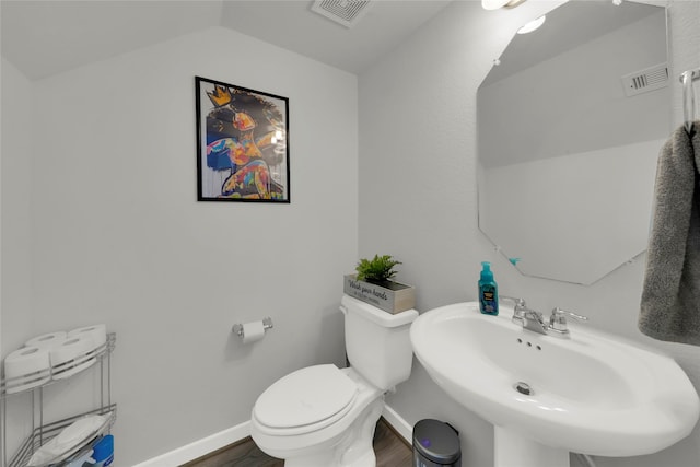 bathroom featuring sink, toilet, wood-type flooring, and vaulted ceiling