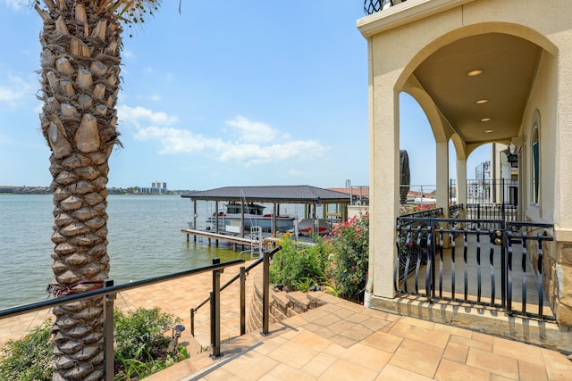 view of patio with a dock and a water view