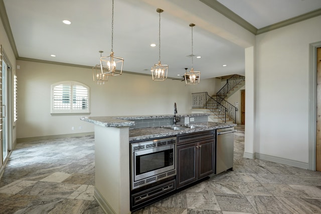 kitchen featuring light stone countertops, sink, dark brown cabinets, stainless steel appliances, and pendant lighting