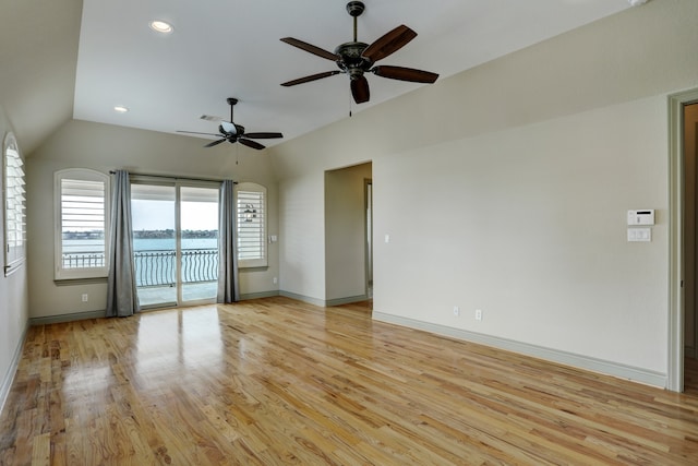 spare room featuring light hardwood / wood-style floors, lofted ceiling, and ceiling fan