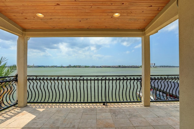 view of patio featuring a water view and a balcony