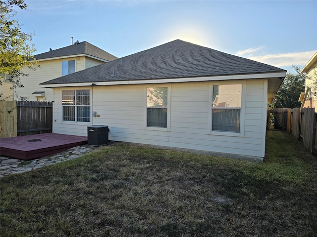 back of house featuring a wooden deck, a lawn, and central AC unit