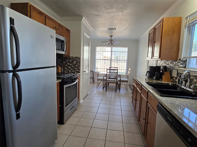 kitchen with sink, decorative backsplash, appliances with stainless steel finishes, and ceiling fan