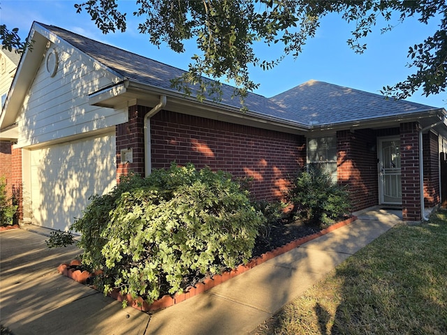 14339 Hillard Green Ln, Houston, TX 77047 - view of side of home with a garage, a shingled roof, driveway, and brick siding