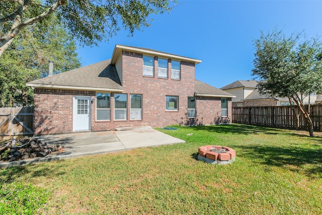 rear view of house with a yard, a patio area, and an outdoor fire pit