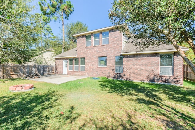 rear view of house with a patio and a lawn