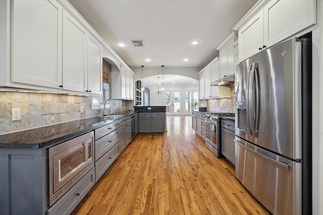 kitchen featuring pendant lighting, sink, appliances with stainless steel finishes, gray cabinetry, and white cabinets