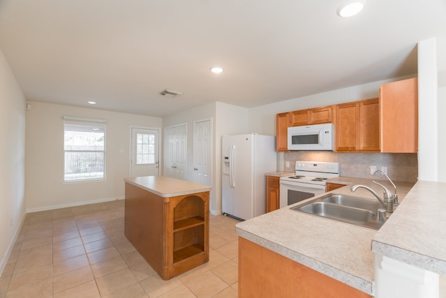 kitchen with kitchen peninsula, light tile patterned floors, backsplash, sink, and white appliances