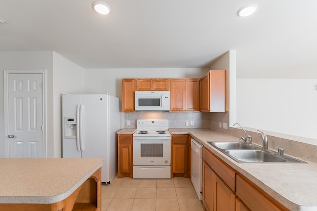 kitchen featuring white appliances, light tile patterned flooring, sink, and kitchen peninsula