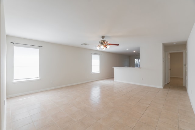 tiled spare room featuring ceiling fan