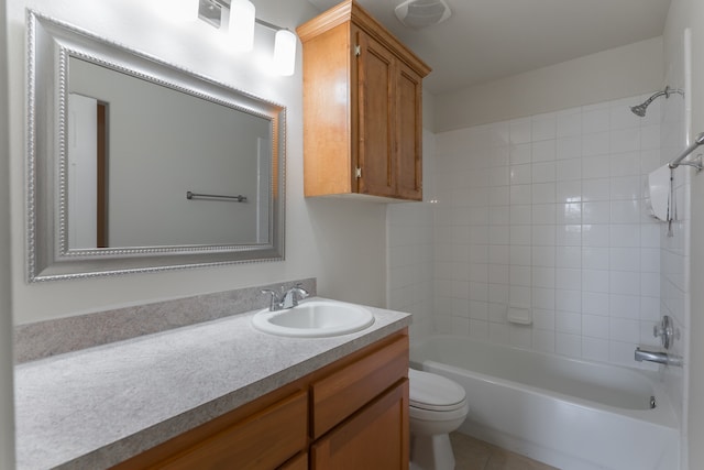 full bathroom featuring tiled shower / bath, vanity, toilet, and tile patterned floors