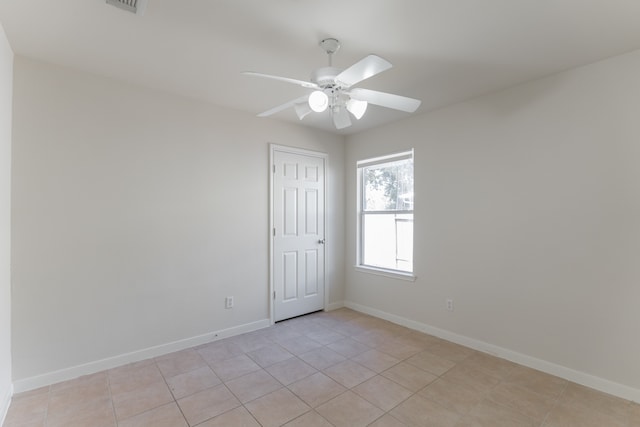 empty room with ceiling fan and light tile patterned floors