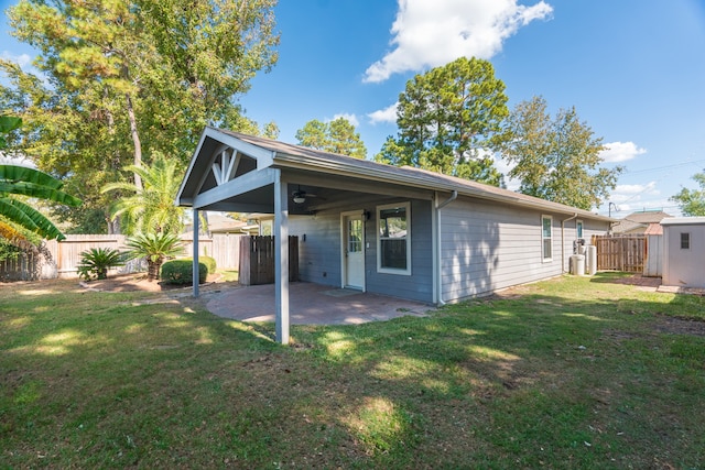 rear view of property with a patio area, a yard, and ceiling fan