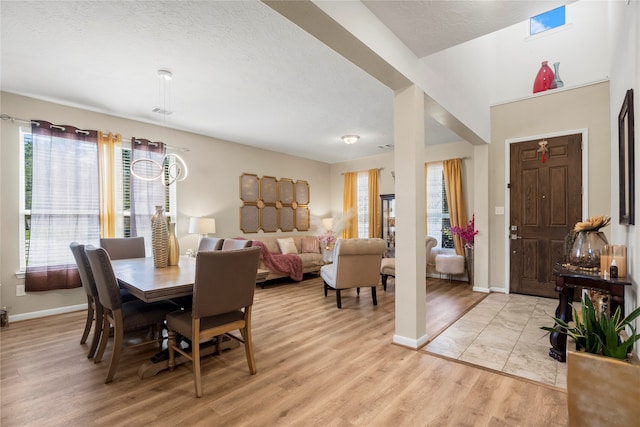 dining room with light hardwood / wood-style floors and a textured ceiling