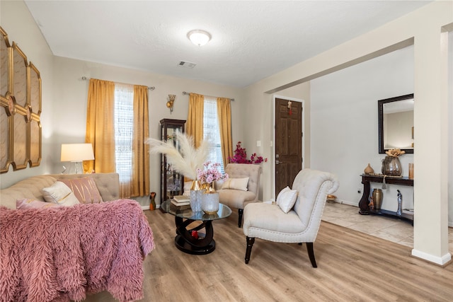 living room featuring light hardwood / wood-style flooring and a textured ceiling