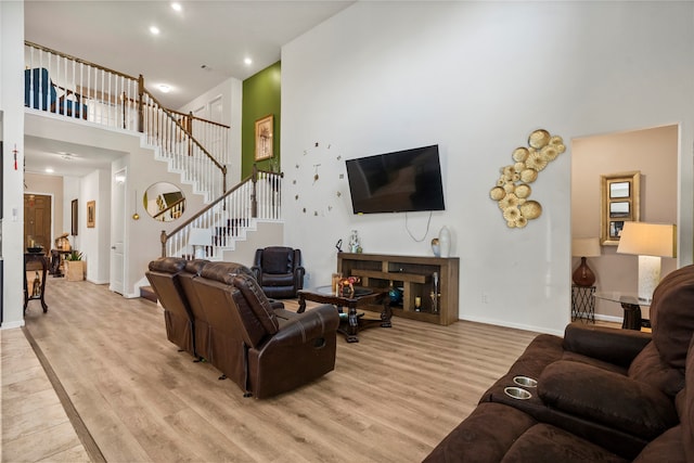 living room with light hardwood / wood-style flooring and a high ceiling