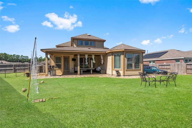 rear view of property with a yard and a patio