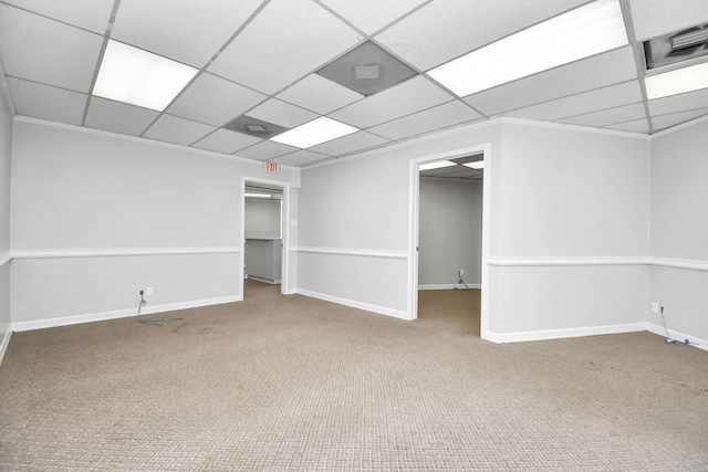 carpeted empty room featuring a drop ceiling