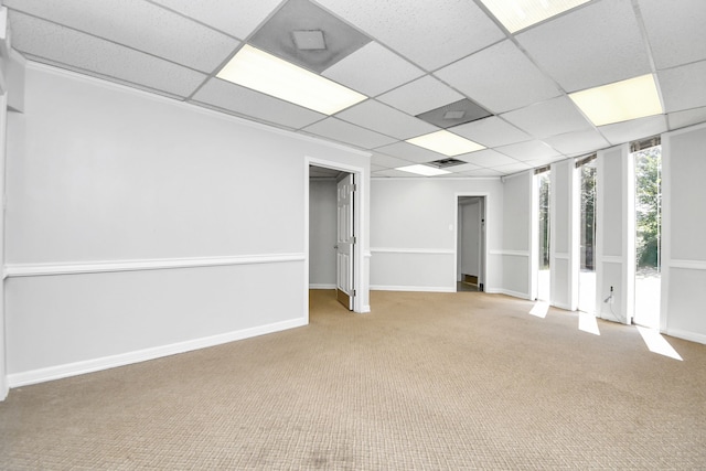 basement featuring light carpet and a paneled ceiling