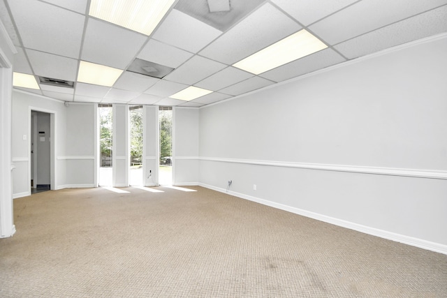 carpeted empty room featuring a drop ceiling