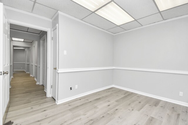 unfurnished room featuring ornamental molding, light hardwood / wood-style flooring, and a paneled ceiling