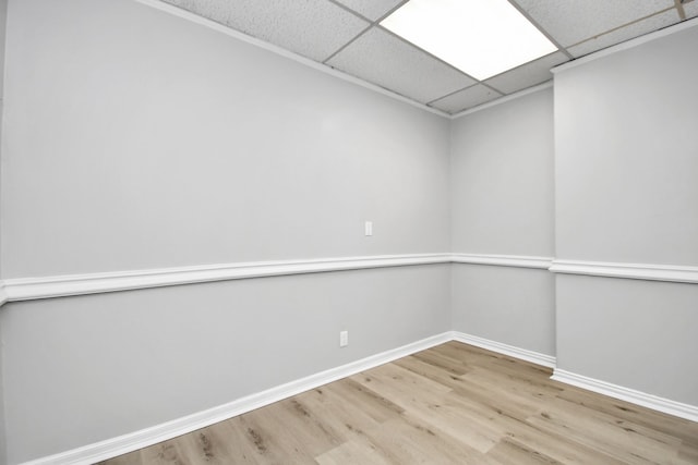 spare room with a paneled ceiling and wood-type flooring