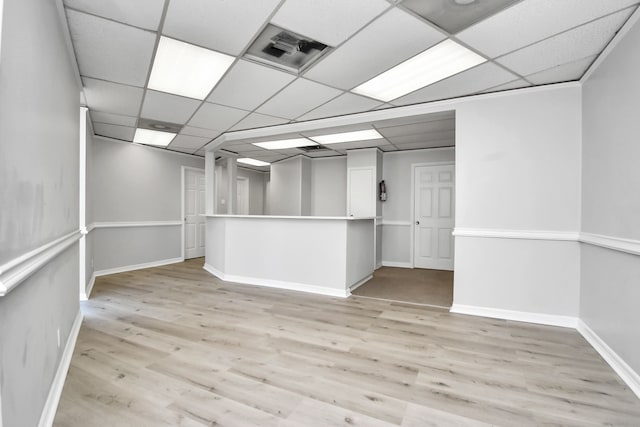 empty room featuring a paneled ceiling and light wood-type flooring